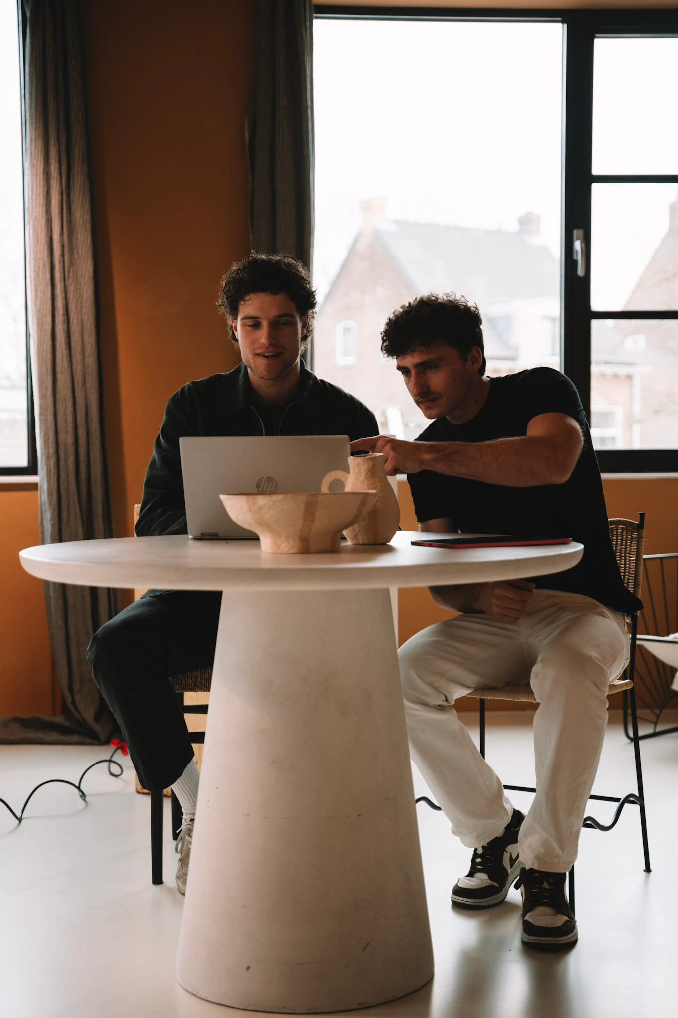 Twee teamleden van Veltman Marketing bekijken samen een laptop aan tafel