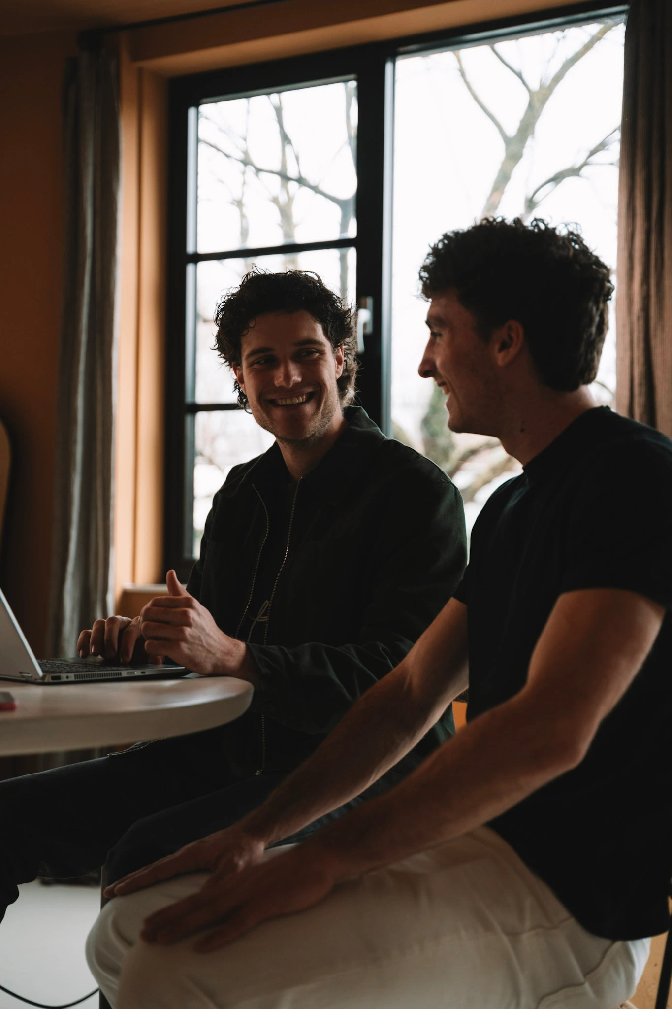 Twee teamleden van Veltman Marketing overleggen aan tafel bij het raam